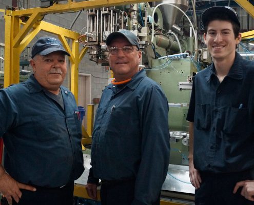 3 Mechanics standing in front of a machine